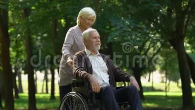 <strong>关爱</strong>的女人在轮椅上支持丈夫，亲吻对方，家人
